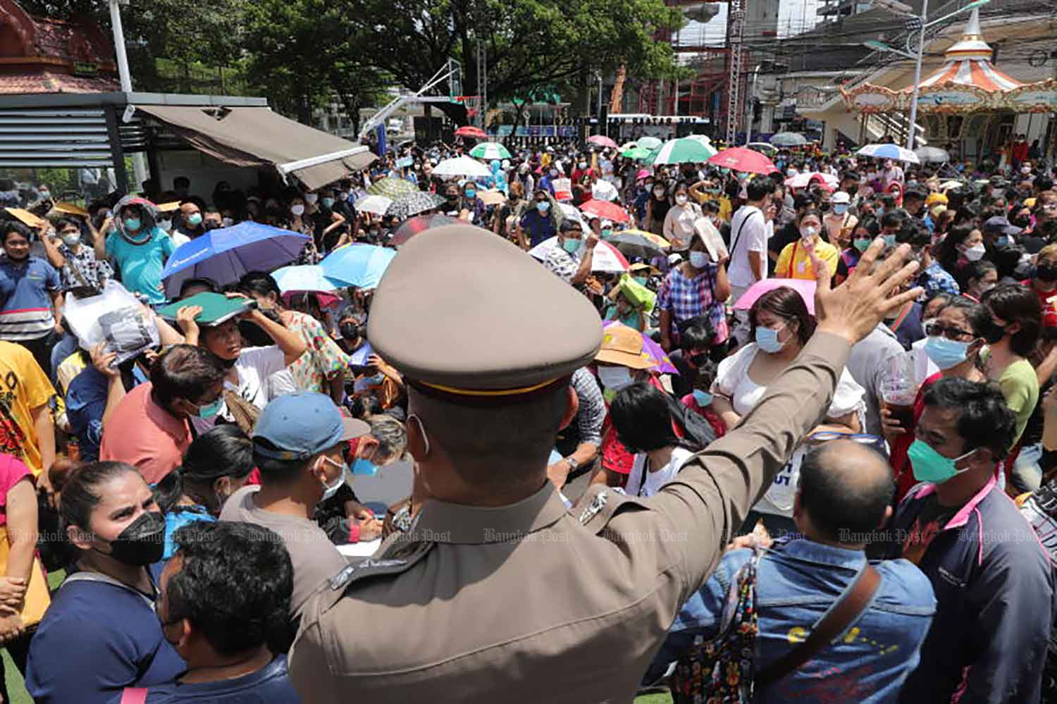 ผู้คนร่วมร้อยมารวมตัวกันที่สำนักงานกองทุนประกันวินาศภัยเพื่อเรียกร้องเงินก้อนสำหรับกรมธรรม์โควิด-19